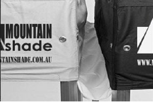 Close-up of two fabric bags, white and black, displaying the Mountain Shade logo and URL.