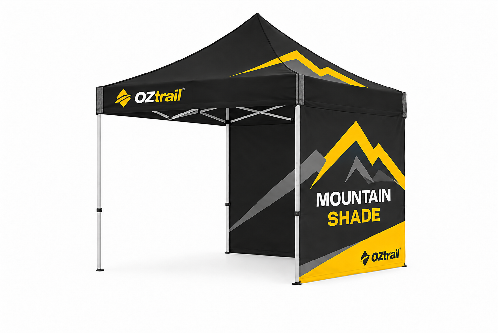 Black pop-up canopy tent with yellow mountain graphics and 'MOUNTAIN SHADE' branding by OZtrail, set up outdoors for promotion.